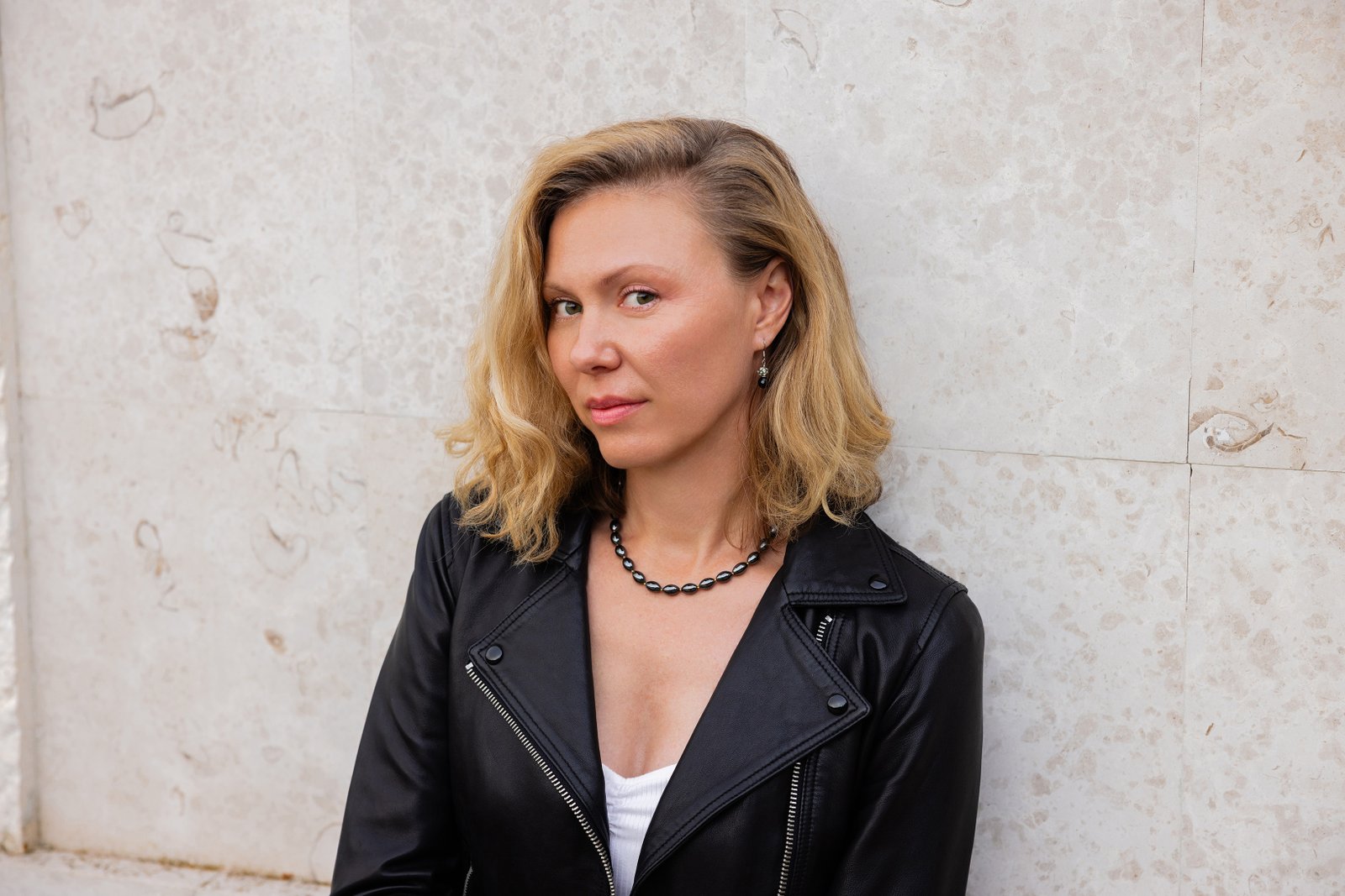 Ivana Benci against a pale limestone wall