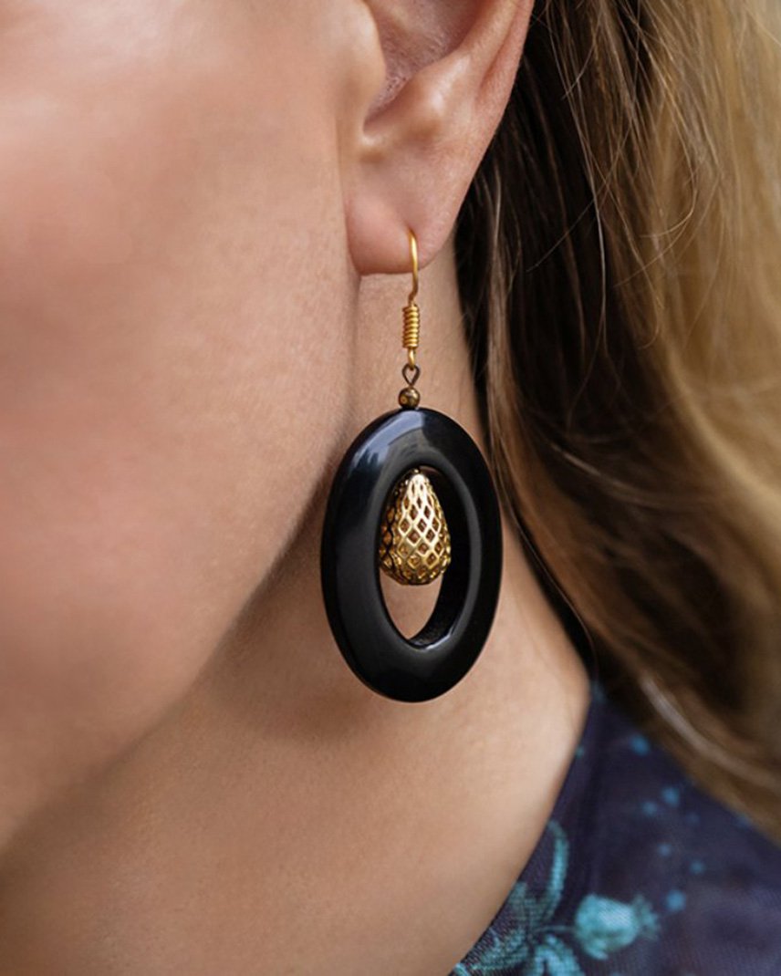 A black onyx hoop earring with a gold filigree drop